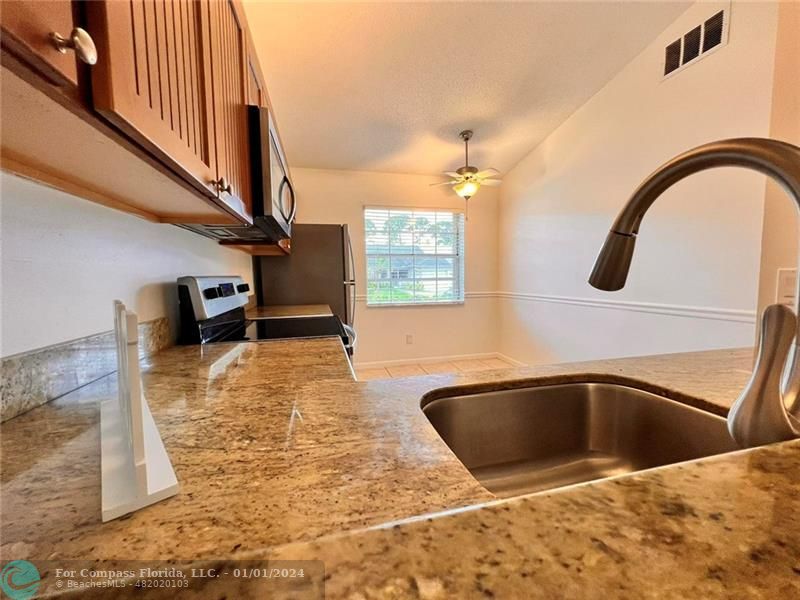 a view of a kitchen sink with granite countertop