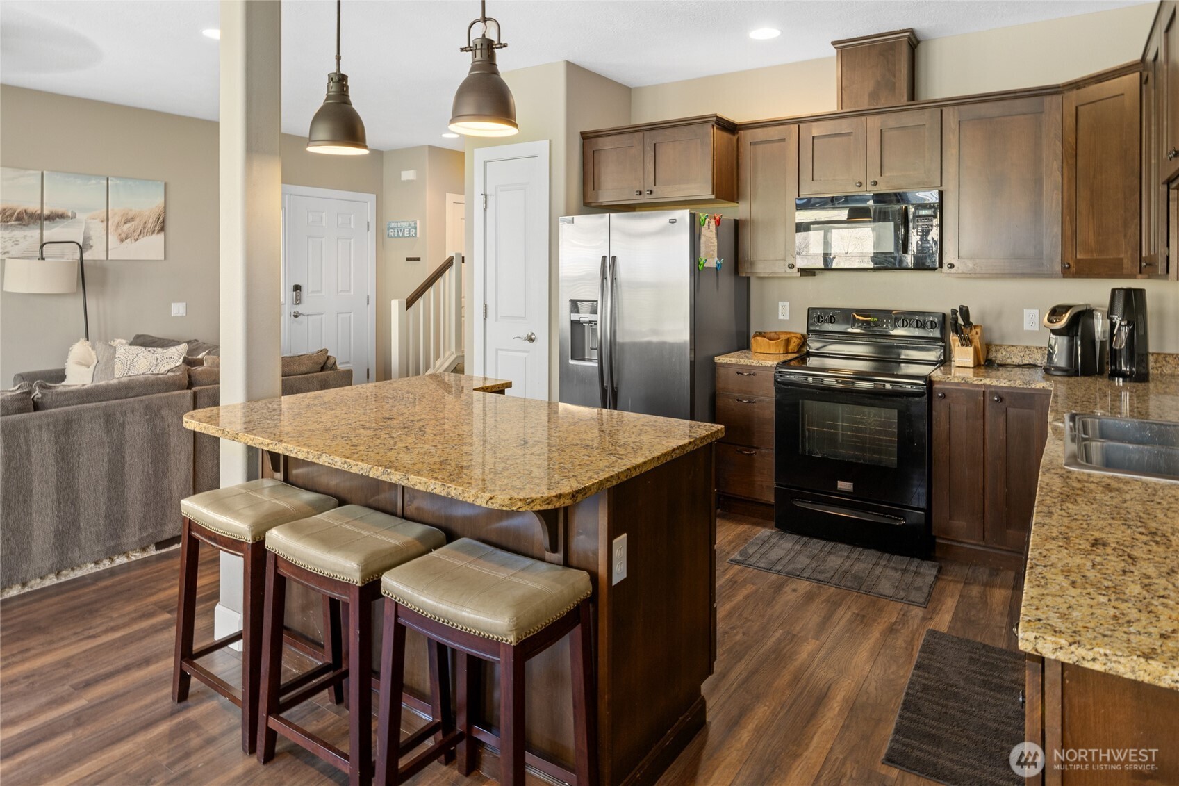 23041 Sunserra Loop Quincy, WA 98848 - Photo 14 of 38 a kitchen with stainless steel appliances granite countertop a kitchen island a table and chairs in it