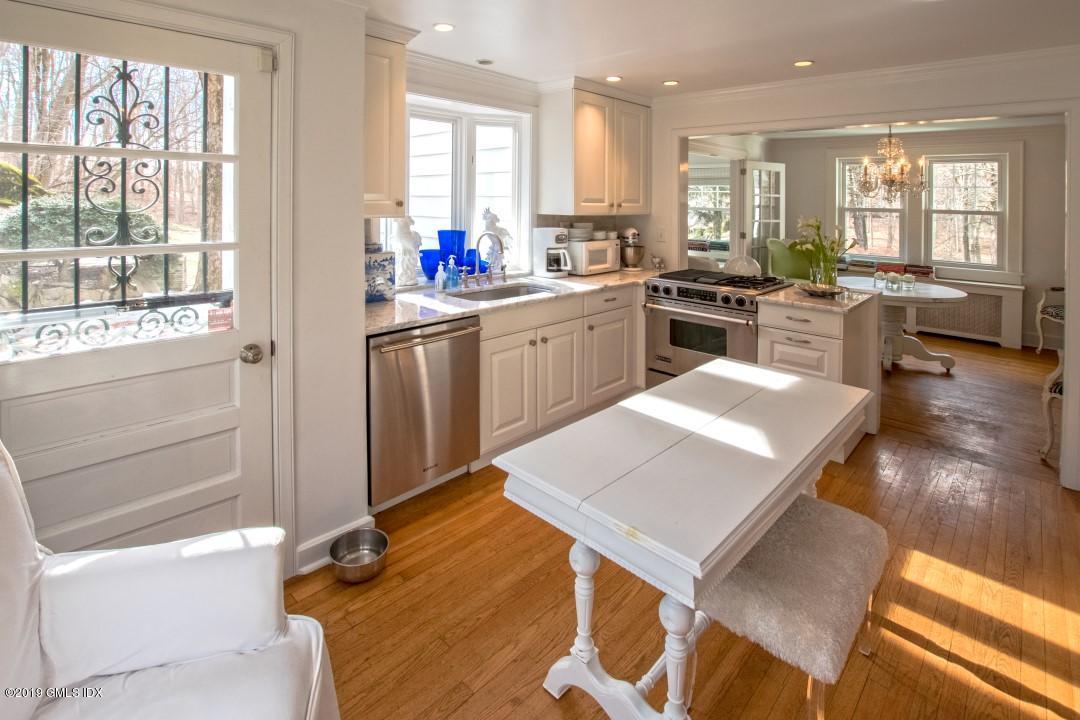347 Riversville Road Greenwich, CT 06831 - Photo 9 of 22 a kitchen with a stove a sink dishwasher a refrigerator and white cabinets with wooden floor