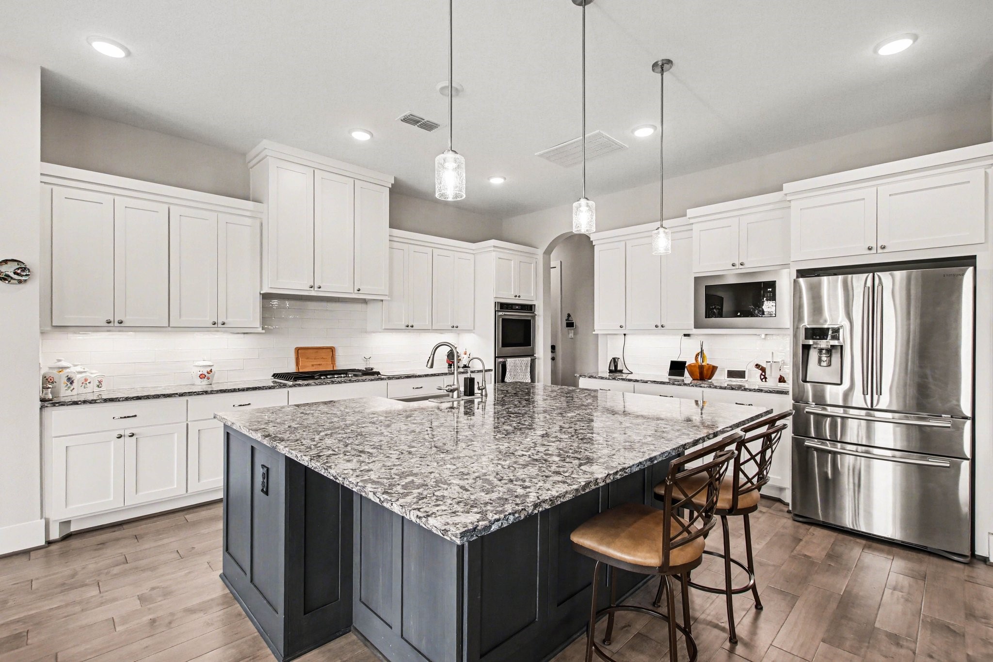 2311 Legends Way Katy, TX 77493 - Photo 18 of 50 The show-stopping island anchors the space with striking quartz, seating for guests, and a built-in sink—perfect for casual gatherings or hosting on a grand scale.