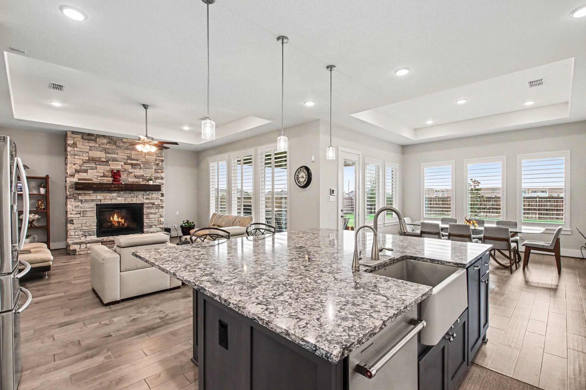 2311 Legends Way Katy, TX 77493 - Photo 20 of 50 Expansive open-concept living area where the chef’s kitchen flows seamlessly into the family room, highlighted by a dramatic floor-to-ceiling stone fireplace.