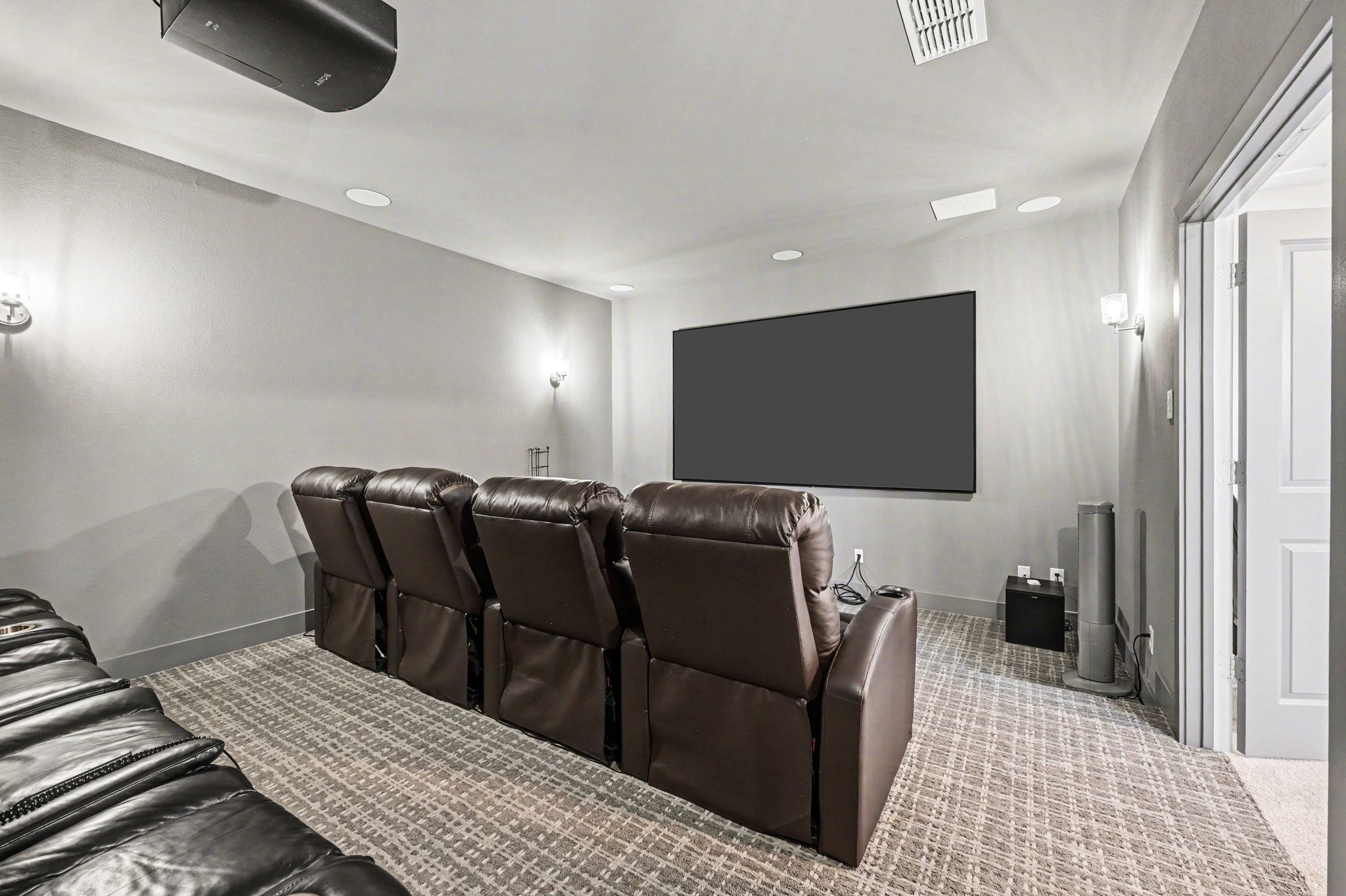 2311 Legends Way Katy, TX 77493 - Photo 26 of 50 Spacious theater-style media room featuring comfortable recliner seating, surround sound setup, and a projector system for an immersive viewing experience.
