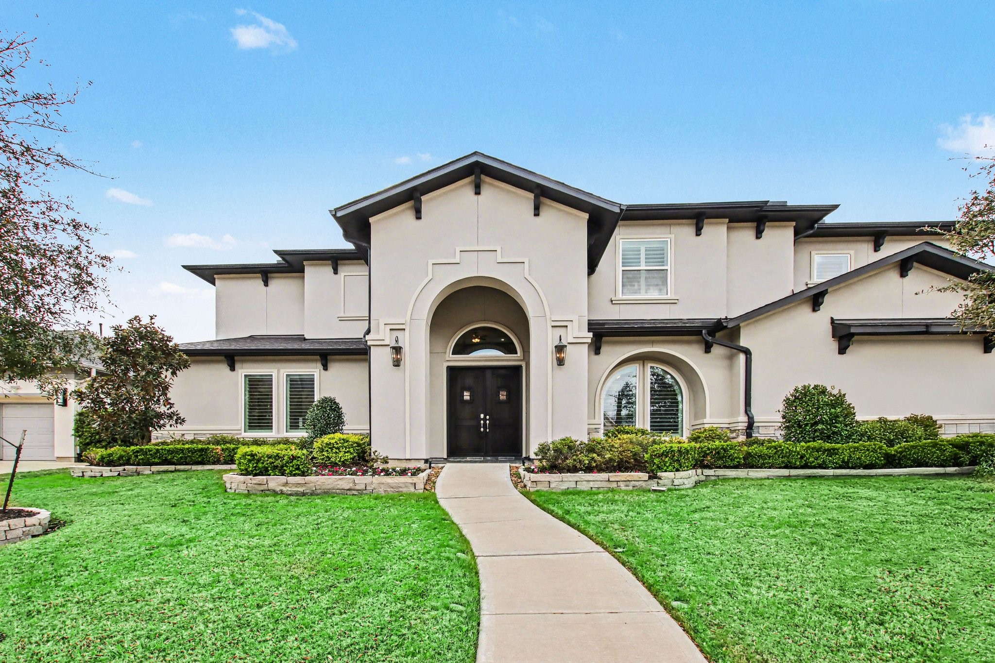 2311 Legends Way Katy, TX 77493 - Photo 3 of 50 Spacious three-car garage and extended driveway provide ample parking while maintaining exceptional curb appeal. Thoughtfully designed landscaping and stone accents elevate the exterior with texture and dimension.