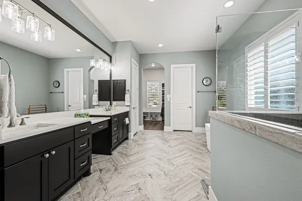 a spacious bathroom with a double vanity sink a mirror and a bathtub