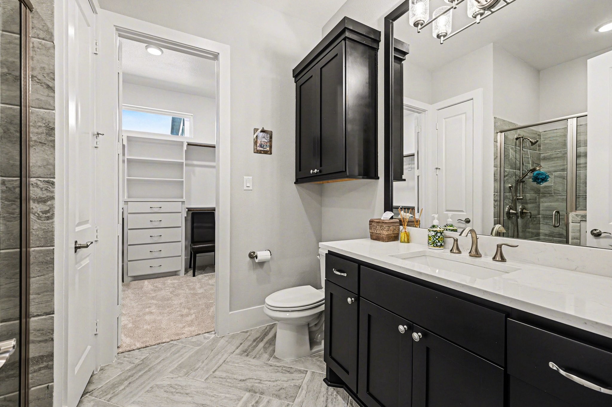 2311 Legends Way Katy, TX 77493 - Photo 34 of 50 Well-appointed secondary bath with quartz countertops, custom cabinetry, and a walk-in shower with designer tile. Direct access to a generous walk-in closet provides both convenience and functionality.