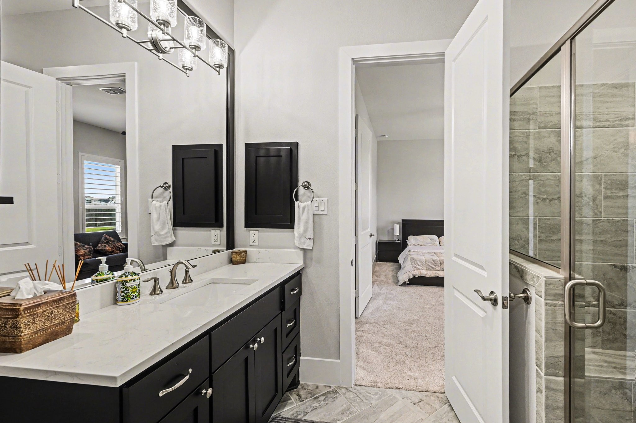 2311 Legends Way Katy, TX 77493 - Photo 35 of 50 Stylishly appointed secondary bath featuring quartz countertops, rich cabinetry, and a sleek glass-enclosed shower with designer tile surround. Modern finishes and clean lines create a polished, move-in-ready feel.