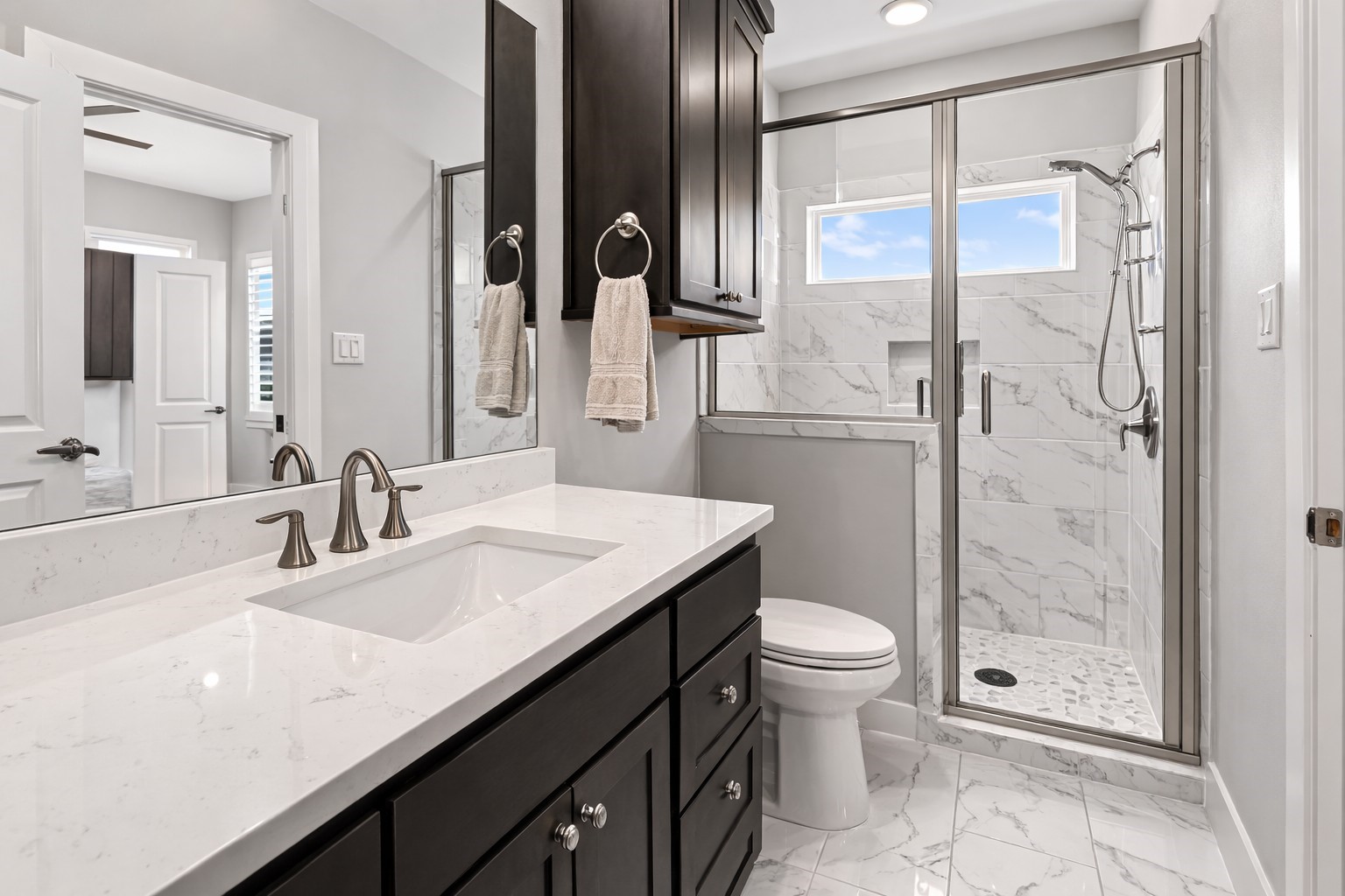 2311 Legends Way Katy, TX 77493 - Photo 37 of 50 Beautifully appointed bathroom with quartz countertops, dark cabinetry, and a frameless glass shower featuring elegant marble-look tile.