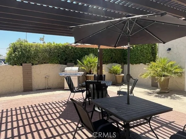 a patio with wooden floor a yard a table and chairs