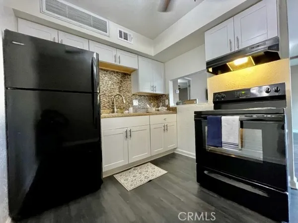 a kitchen with a refrigerator stove and white cabinets
