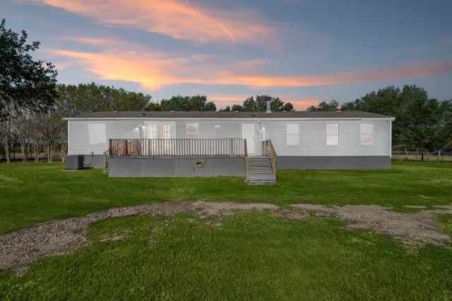 a view of a house with a backyard and a garden