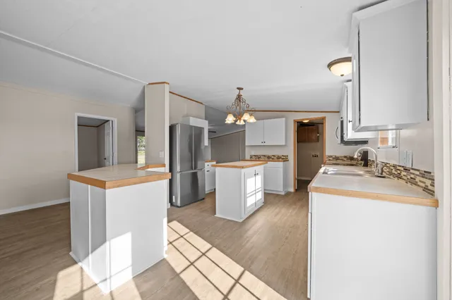 a kitchen with a sink a stove top oven and cabinetry