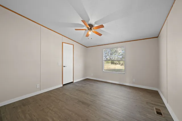 an empty room with windows and fan