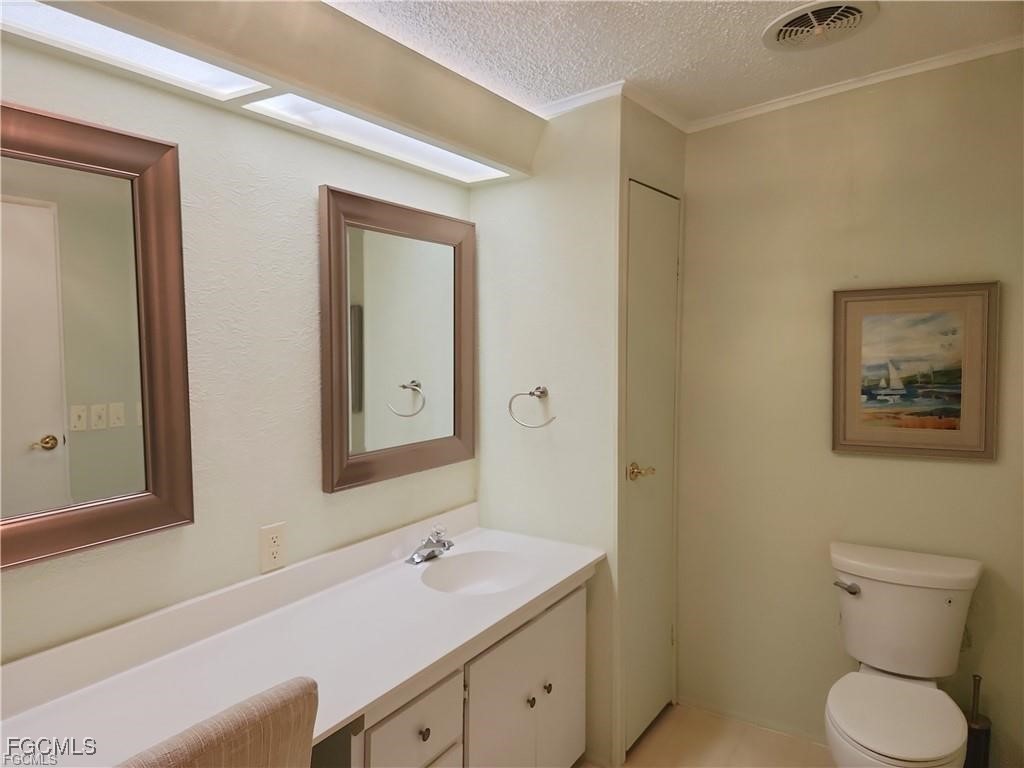 10401 Circle Pine Road North Fort Myers, FL 33903 - Photo 17 of 20 a bathroom with a toilet sink and mirror