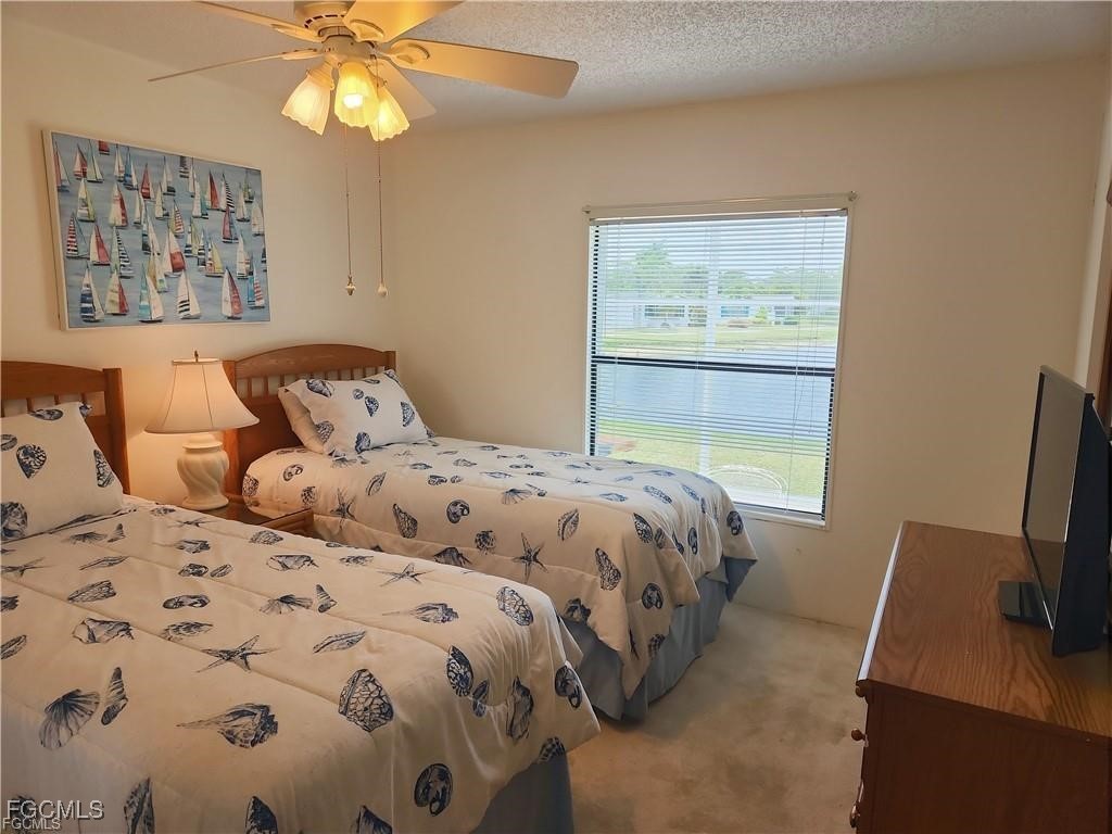 10401 Circle Pine Road North Fort Myers, FL 33903 - Photo 18 of 20 a bedroom with a bed and a flat tv screen on dresser