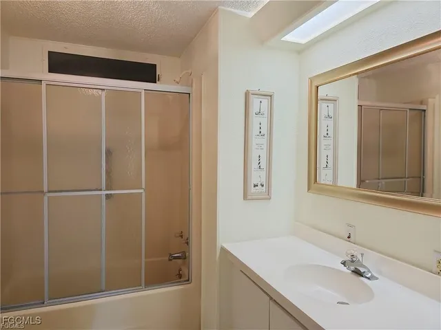 a bathroom with a shower sink and mirror
