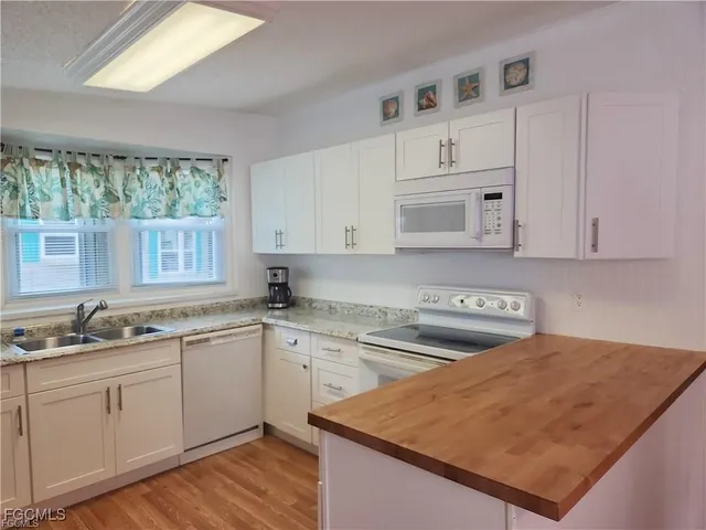 a kitchen with white cabinets sink and stove