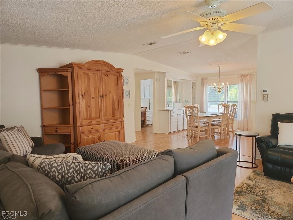 10401 Circle Pine Road North Fort Myers, FL 33903 - Photo 8 of 20 a living room with furniture a chandelier and a dining room