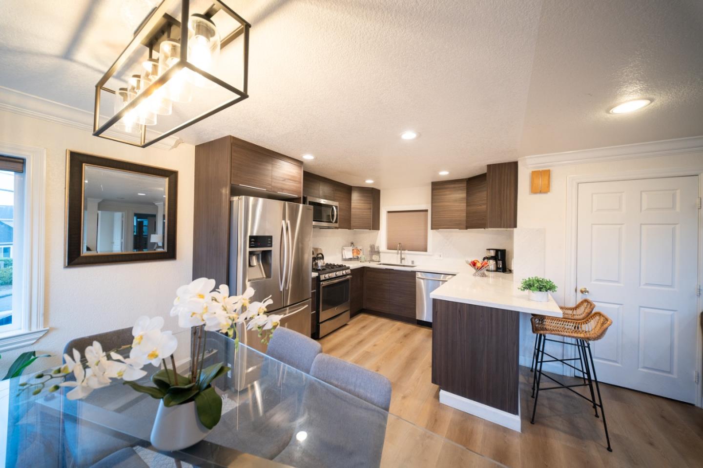 301 Channing Way Pacifica, CA 94044 - Photo 8 of 68 a kitchen with stainless steel appliances kitchen island granite countertop a refrigerator a stove a sink dishwasher a dining table and chairs with wooden floor