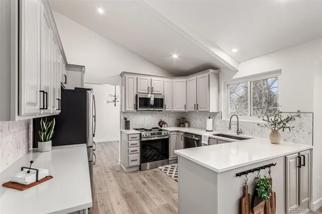 a kitchen with stainless steel appliances a stove refrigerator sink and microwave