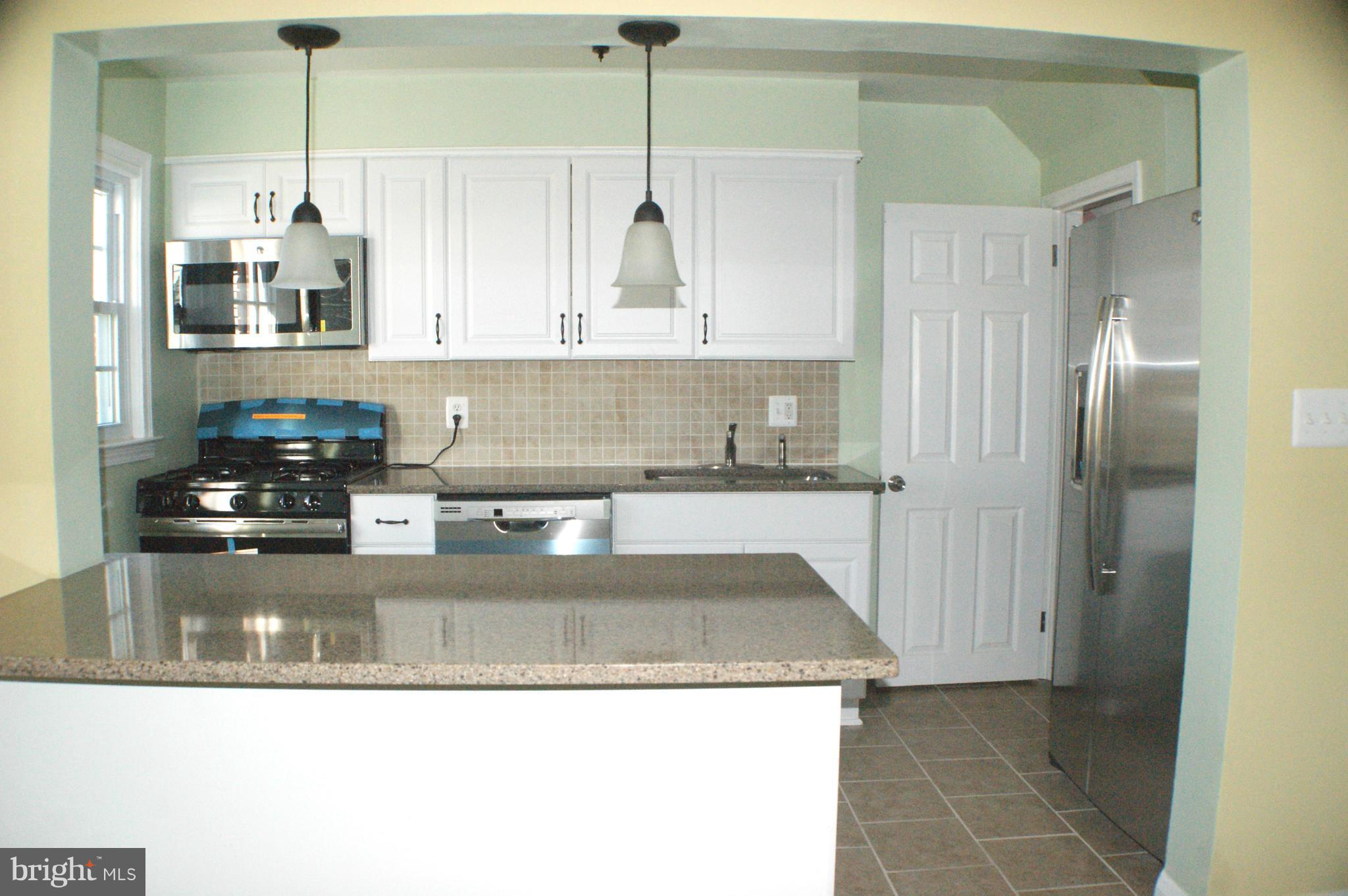 1917 Nevill Road Baltimore, MD 21222 - Photo 8 of 23 a kitchen with stainless steel appliances granite countertop a sink a stove and a refrigerator