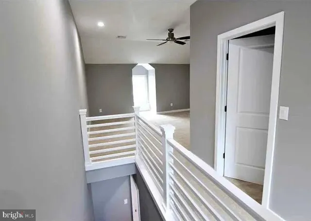 a view of a hallway with wooden floor and staircase