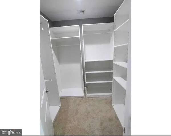 a view of walk in closet with empty racks
