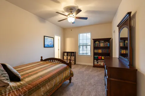 a bedroom with a bed furniture and a book shelf