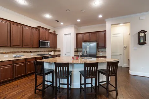 a kitchen with stainless steel appliances granite countertop a stove a sink a microwave a dining table and chairs