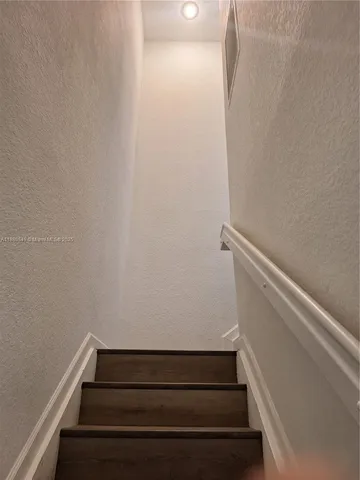 a kitchen with granite countertop white cabinets and stainless steel appliances