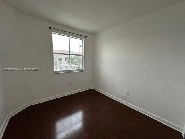 an empty room with wooden floor and closet
