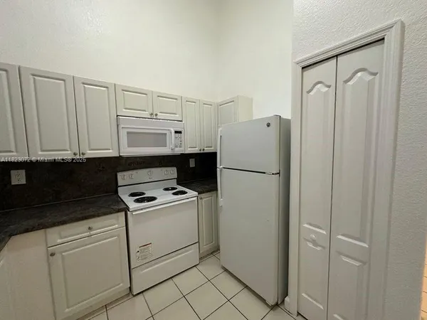 a white refrigerator freezer sitting inside of a kitchen