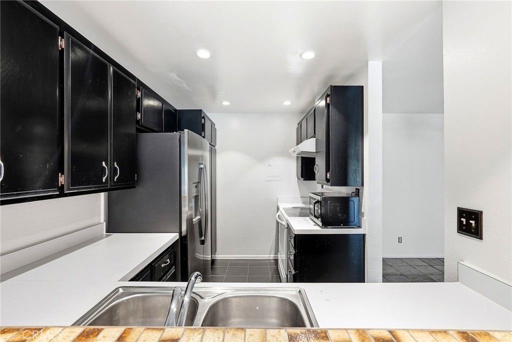 7890 East Spring Street, Unit 11E Long Beach, CA 90815 - Photo 20 of 40 a view of a kitchen with a sink and refrigerator