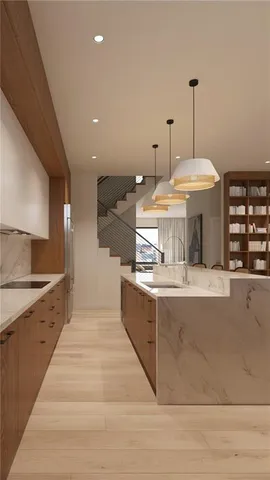 a large kitchen with stainless steel appliances a large counter top a stove and a sink