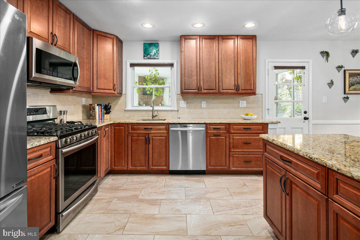 5913 4th Road North Arlington, VA 22203 - Photo 15 of 45 a kitchen with stainless steel appliances granite countertop wooden cabinets a stove top oven a sink and dishwasher