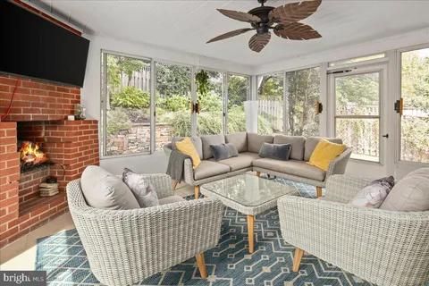 a living room with furniture a flat screen tv and a large window