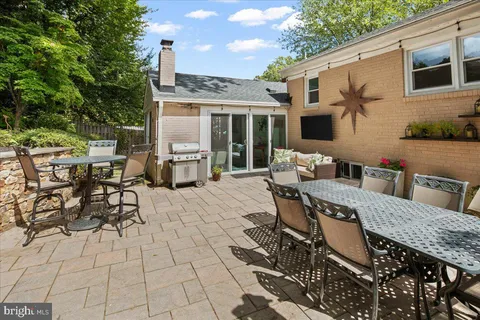 a view of a patio with table and chairs potted plants with wooden floor and fence