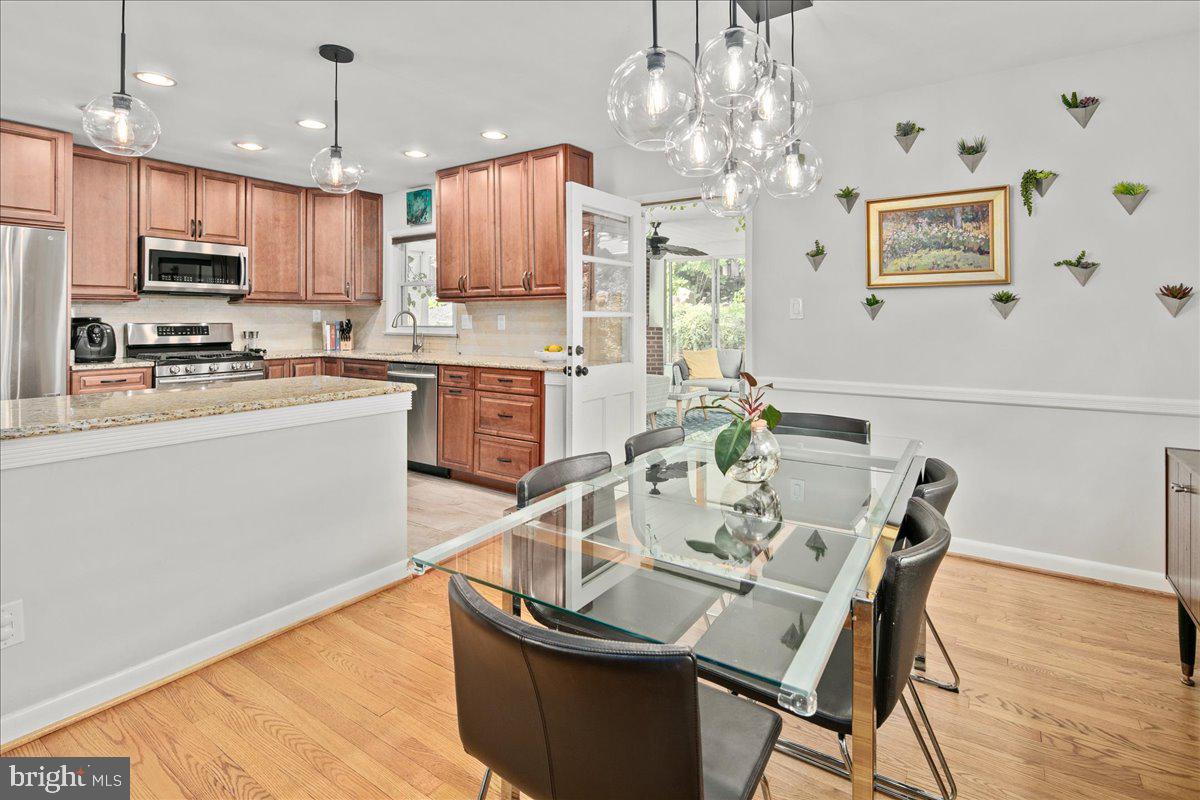 5913 4th Road North Arlington, VA 22203 - Photo 10 of 45 a kitchen with granite countertop a table chairs microwave and cabinets