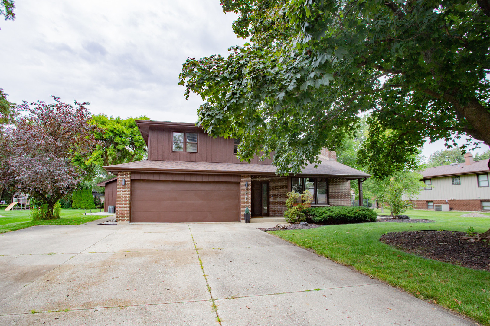 a front view of a house with a yard and trees
