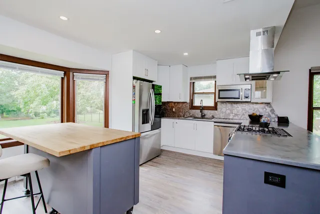 a kitchen with stainless steel appliances granite countertop sink refrigerator and microwave