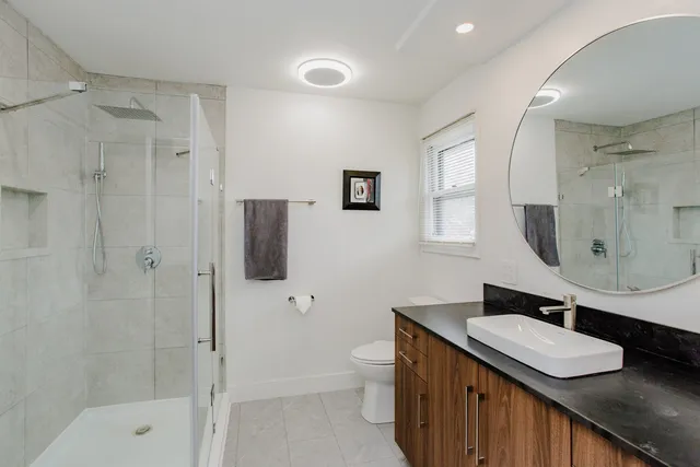 a bathroom with a sink a toilet and shower