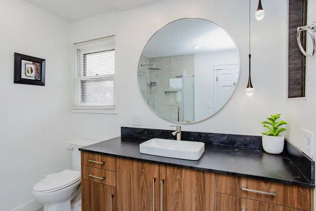 a bathroom with a sink a toilet and a mirror
