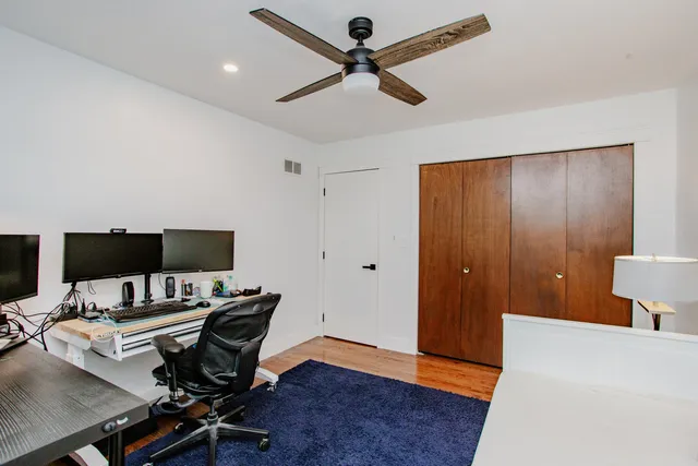 a view of a workspace with furniture and a ceiling fan