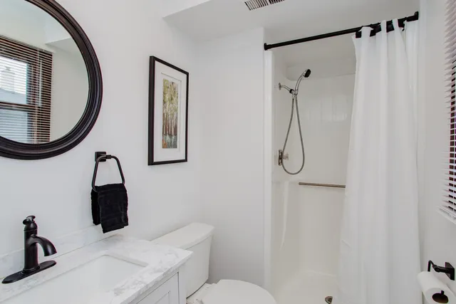 a bathroom with a sink vanity mirror and toilet