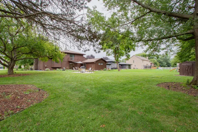 a view of a house with a big yard and large trees