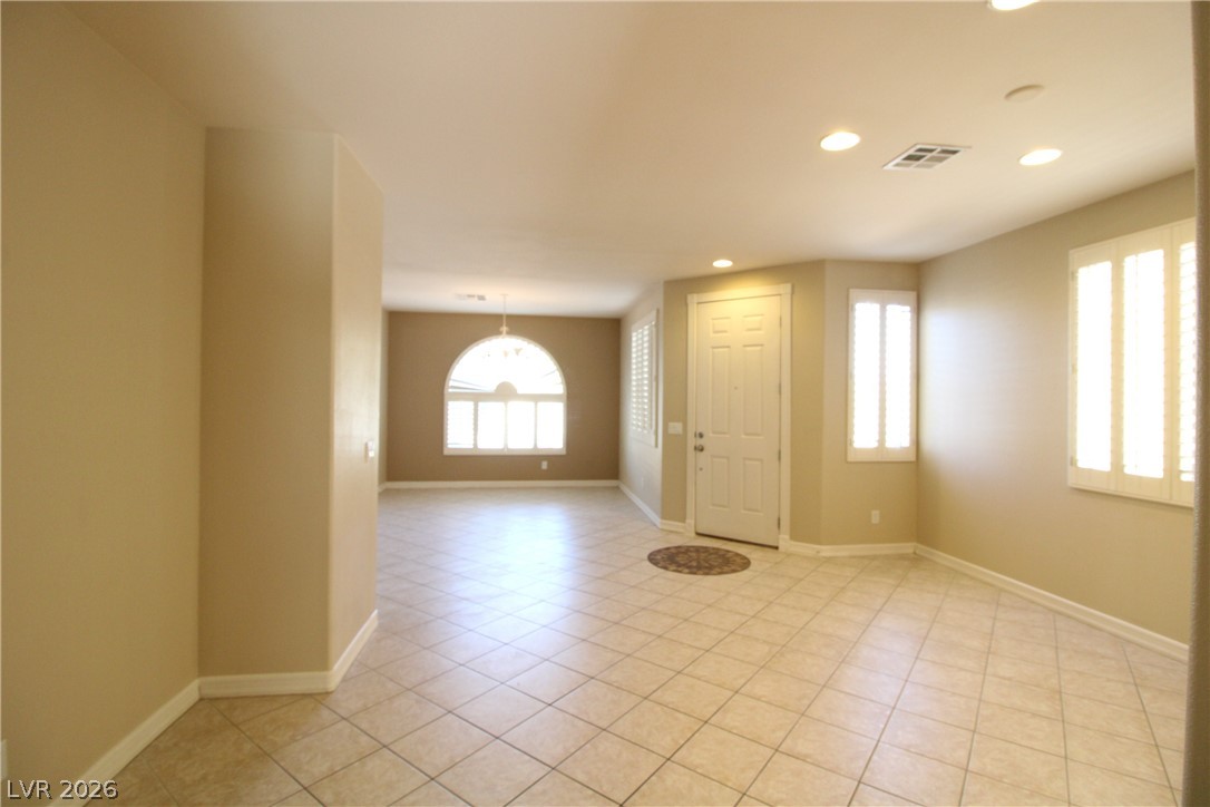 754 Rise Canyon Drive Henderson, NV 89052 - Photo 18 of 34 A welcoming entry space features tile flooring and an arched window, filling the area with natural light.