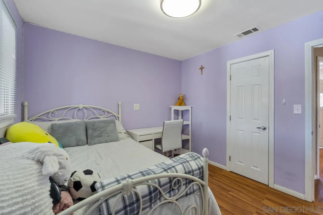 13139 Carriage Road Poway, CA 92064 - Photo 24 of 43 a bedroom with a bed and wooden floor