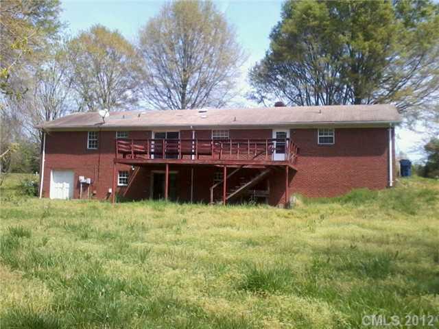 5879 Alexander Road Concord, NC 28027 - Photo 3 of 7 a house is sitting in middle of the green field
