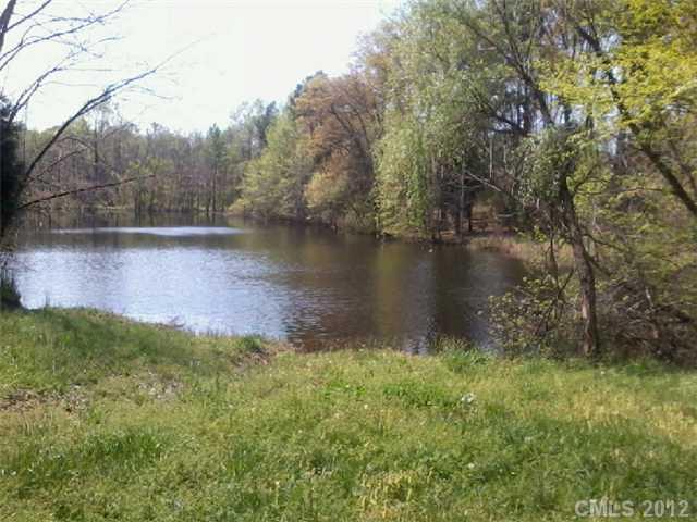 5879 Alexander Road Concord, NC 28027 - Photo 5 of 7 a view of a lake with a yard and large trees