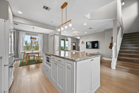 a kitchen with stainless steel appliances granite countertop a lot of counter space and wooden floors