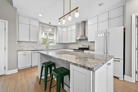 a kitchen with stainless steel appliances granite countertop a sink stove and refrigerator